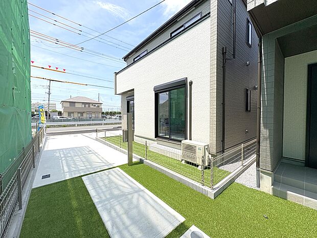 【B号棟 外観】建物南側に 庭スペース（人工芝）と隣地通路の空間・日当たり良好