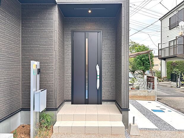 【玄関】玄関へ向かうまでのアプローチに漂う上質が期待感をもたせます。玄関は建物の顔。落着きを醸し出した自己主張が心に訴えてきます。