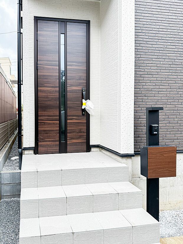 【玄関】玄関へ向かうまでのアプローチに漂う上質が期待感をもたせます。玄関は建物の顔。落着きを醸し出した自己主張が心に訴えてきます。