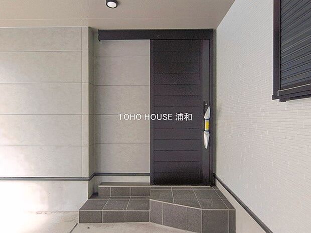 2号棟【玄関】玄関へ向かうまでのアプローチに漂う上質が期待感をもたせます。玄関は建物の顔。落着きを醸し出した自己主張が心に訴えてきます。