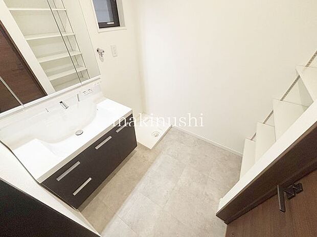 洗面清潔感溢れるスタイリッシュなデザインの洗面化粧台。手元に洗顔料やメイク道具を置くスペースがあり便利です。