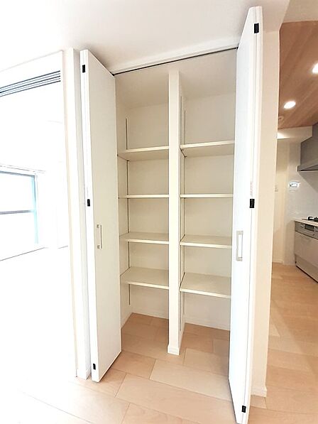リビングには大容量の可動棚付き収納を完備!買い置きの食材や日用品のストック、掃除用具まで、中身に合わせて高さを変えてスッキリ収納できます。