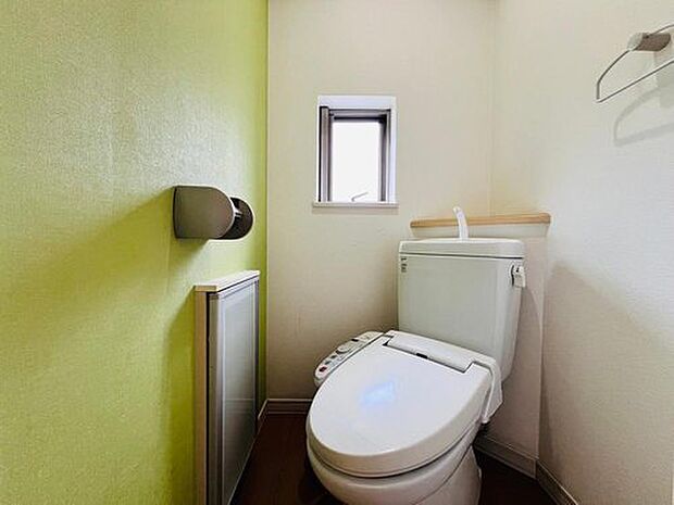 ポップな黄緑色のアクセントクロス入りのトイレ。小窓もあって換気良し。