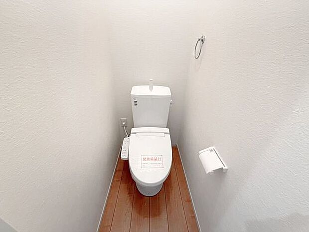 1階トイレ。シンプルな内装と清潔感のある白いトイレ。毎日のトイレタイムは落ち着ける空間がいいですよね。手洗い付きのトイレなので手を洗うこともでき、また、タオルを設置できるタオル掛けもあります。