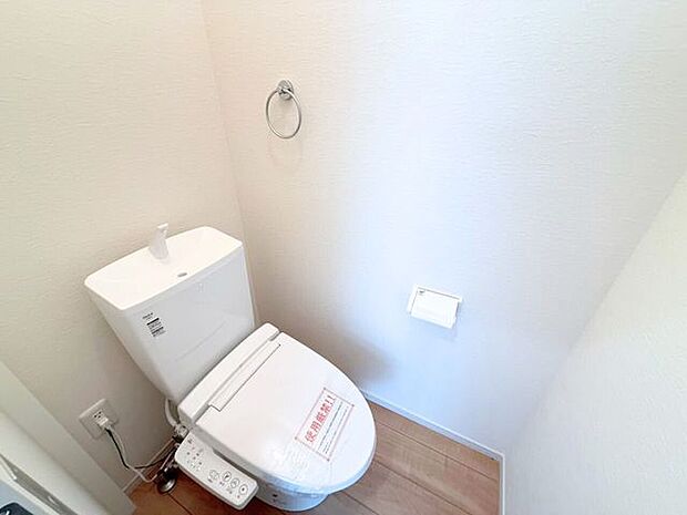 1階トイレ。シンプルな内装と清潔感のある白いトイレ。毎日のトイレタイムは落ち着ける空間がいいですよね。手洗い付きのトイレなので手を洗うこともでき、また、タオルを設置できるタオル掛けもあります。