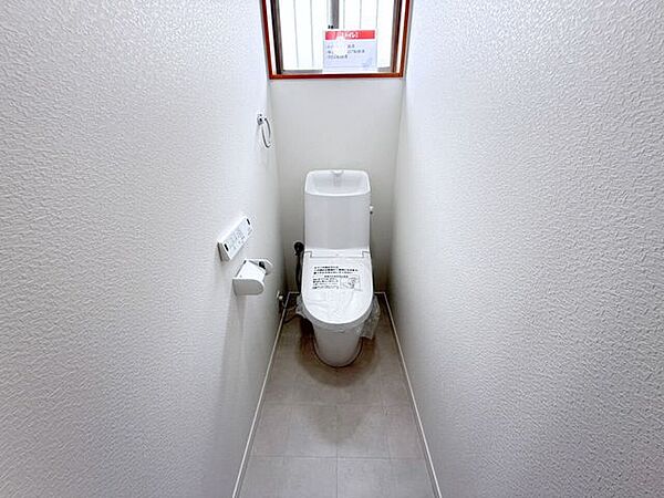 1階トイレ。シンプルな内装と清潔感のある白いトイレ。毎日のトイレタイムは落ち着ける空間がいいですよね。手洗い付きのトイレなので手を洗うこともでき、また、タオルを設置できるタオル掛けもあります。