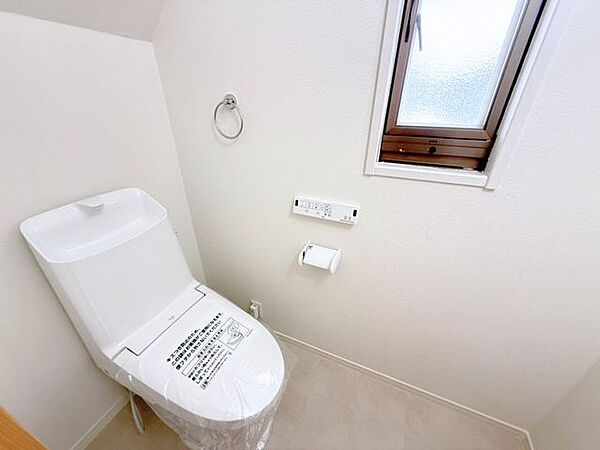 1階トイレ。シンプルな内装と清潔感のある白いトイレ。毎日のトイレタイムは落ち着ける空間がいいですよね。手洗い付きのトイレなので手を洗うこともでき、また、タオルを設置できるタオル掛け付き。