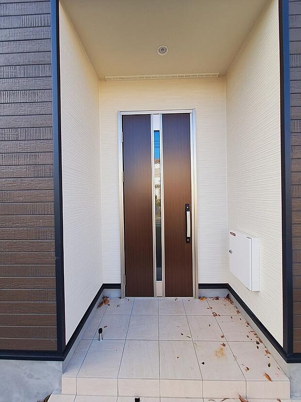 落ち着きのあるブラウンのドアが目印の玄関になります。玄関灯は人感センサー付きで。ピッキング対策付き玄関ドア、TVモニター付きインターホンで防犯面も安心です。