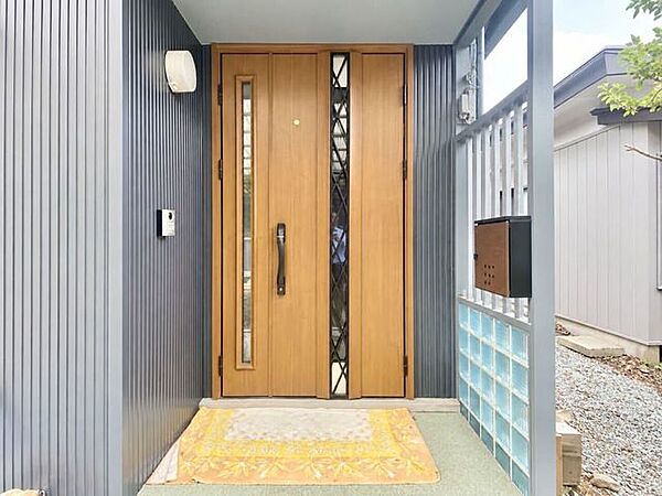 木目調の玄関扉が温かな印象を与える住まいの入口。屋根があるため、雨天時の鍵の開閉もスムーズに行えます。