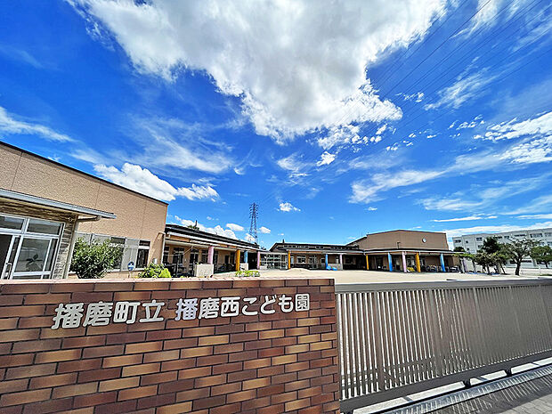 播磨町立播磨西こども園まで約1100m 　教育目標は「生きる力」の基礎をはぐくむこと。園舎は明るく、柱の色は青色「知・考える力」ピンク色「徳・やさしい心」黄色「体・元気な体」を表しています。