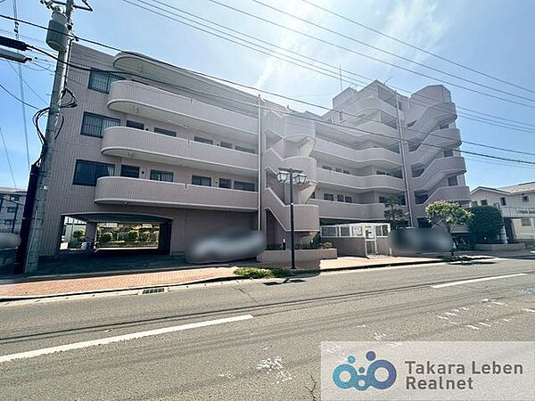 柔らかな印象で、周囲の街並みと調和する、シンプルで優しいデザインの外観です。