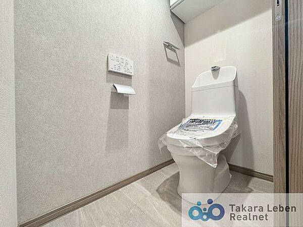 ウォシュレット機能付きのトイレは壁掛けリモコンの上位グレードを採用。便座がスッキリした印象となり、限られた空間を広く見せる効果があります。