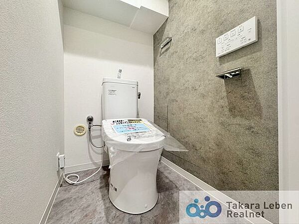 ウォシュレット機能付きのトイレは壁掛けリモコンの上位グレードを採用。便座がスッキリした印象となり、限られた空間を広く見せる効果があります。