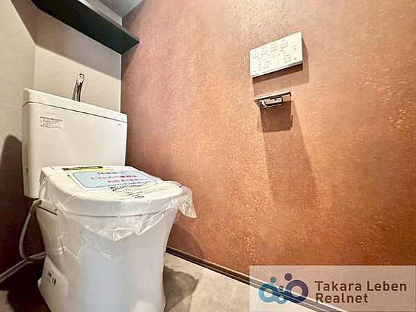 ウォシュレット機能付きのトイレは壁掛けリモコンの上位グレードを採用。便座がスッキリした印象となり、限られた空間を広く見せる効果があります。