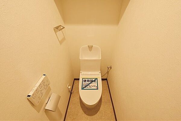 ウォシュレット機能付きのトイレ。壁面に収納棚が設置されているので、備品の収納もできますね！