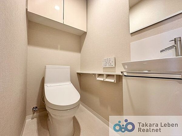 ウォシュレット機能付きのトイレ。ペーパーホルダーやタオル掛けは標準装備しています。