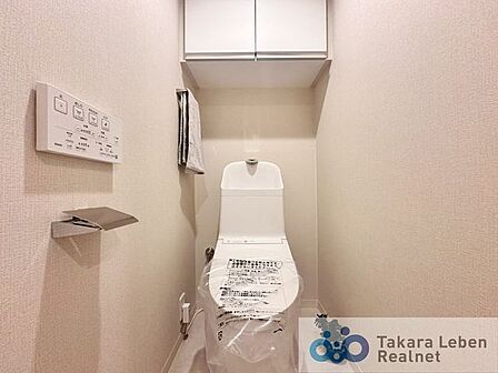 ウォシュレット機能付きのトイレは壁掛けリモコンの上位グレードを採用。便座がスッキリした印象となり、限られた空間を広く見せる効果があります。