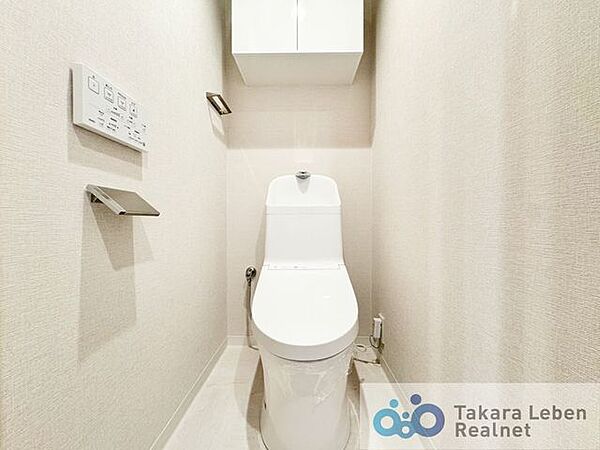 ウォシュレット機能付きのトイレは壁掛けリモコンの上位グレードを採用。便座がスッキリした印象となり、限られた空間を広く見せる効果があります。