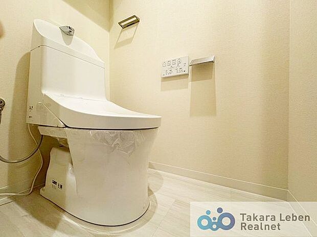 ウォシュレット機能付きのトイレは壁掛けリモコンの上位グレードを採用。便座がスッキリした印象となり、限られた空間を広く見せる効果があります。