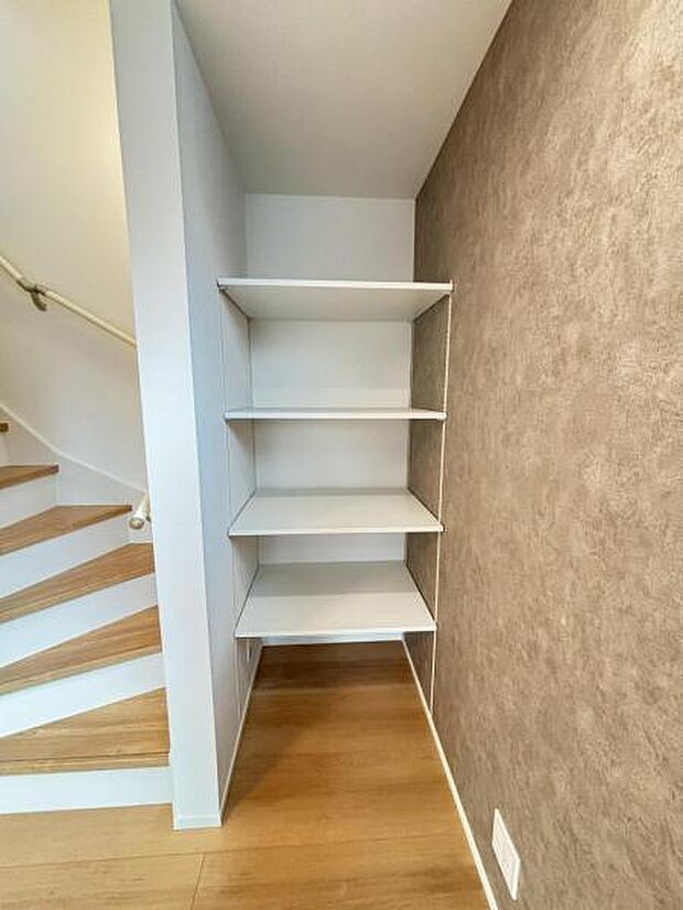 階段横には、空間を効率的に利用し稼働棚の収納スペースを設置。多目的にお使いいただける便利な空間です。