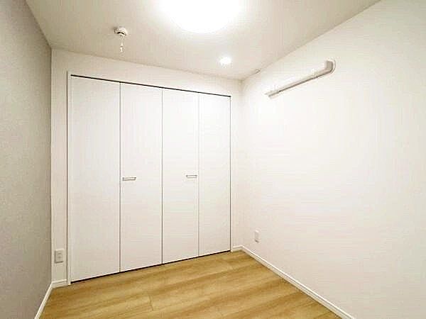 やさしい陽射しが差し込む寝室は、心地よい眠りへと誘う癒しの空間。木目調の床と白を基調とした壁が、清潔感とやわらかな印象を与え、毎日の疲れをそっと包み込みます。