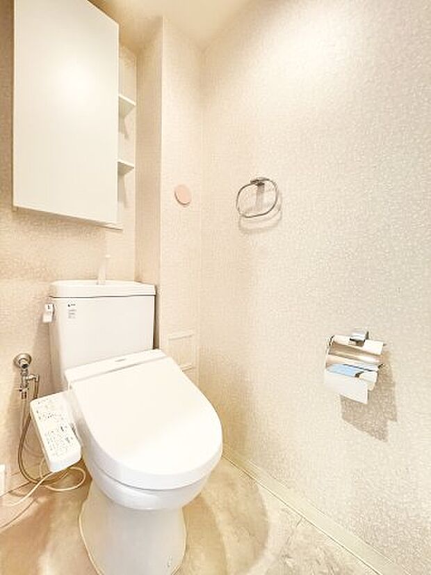 温水洗浄機能付きトイレ。上部に収納があり、余裕のある空間です。