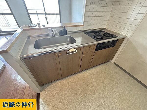 機能的なシンクとコンロを備えたキッチンは、日々の料理を快適にサポートします。収納スペースも確保され、使いやすさに配慮された設計です。