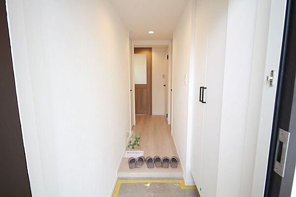 【廊下】白の壁紙と温かみのある木目調が美しく調和した、洗練された空間。