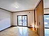 寝室：大きな窓から陽光が差し込む、明るく快適なお部屋です。