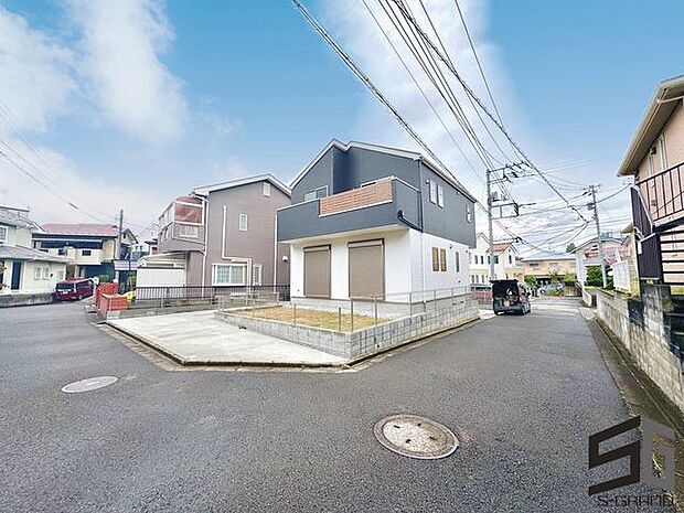 広々とした前面道路に面し、車の出し入れがしやすい現地外観。ゆとりある駐車スペースと開放感のある立地が魅力で、毎日の暮らしに快適さと安心をもたらすマイホームです。