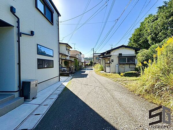 広々とした前面道路に面し、車の出し入れがしやすい現地外観。ゆとりある駐車スペースと開放感のある立地が魅力で、毎日の暮らしに快適さと安心をもたらすマイホームです。