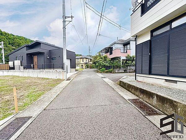 広々とした前面道路に面し、車の出し入れがしやすい現地外観。ゆとりある駐車スペースと開放感のある立地が魅力で、毎日の暮らしに快適さと安心をもたらすマイホームです。