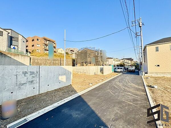 広々とした前面道路に面し、車の出し入れがしやすい現地外観。ゆとりある駐車スペースと開放感のある立地が魅力で、毎日の暮らしに快適さと安心をもたらすマイホームです。
