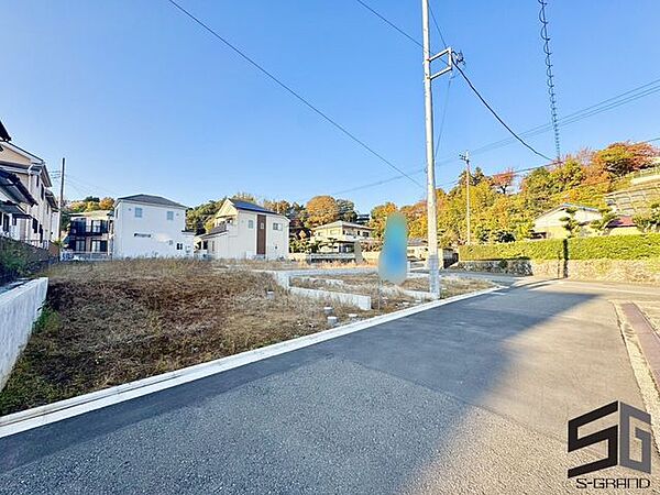 広々とした前面道路に面し、車の出し入れがしやすい現地外観。ゆとりある駐車スペースと開放感のある立地が魅力で、毎日の暮らしに快適さと安心をもたらすマイホームです。