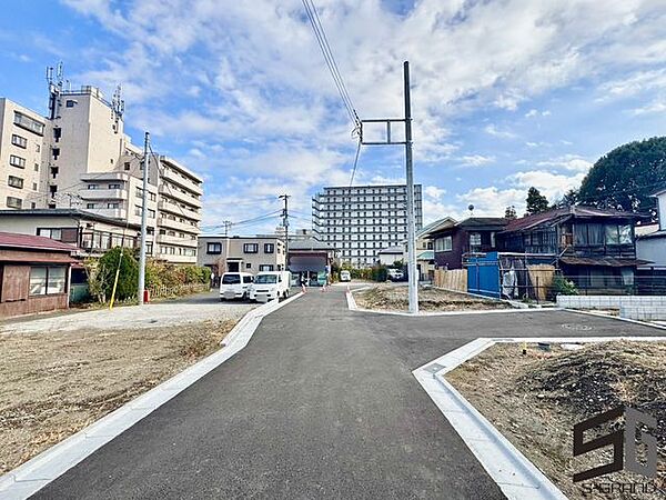 広々とした前面道路に面し、車の出し入れがしやすい現地外観。ゆとりある駐車スペースと開放感のある立地が魅力で、毎日の暮らしに快適さと安心をもたらすマイホームです。