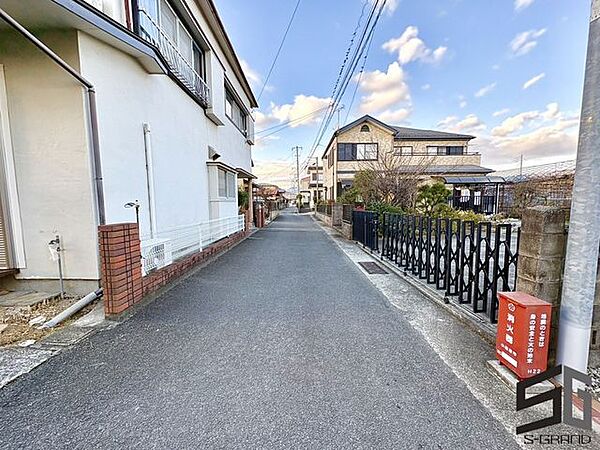 広々とした前面道路に面し、車の出し入れがしやすい現地外観。ゆとりある駐車スペースと開放感のある立地が魅力で、毎日の暮らしに快適さと安心をもたらすマイホームです。