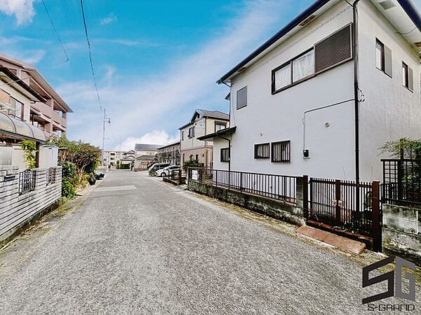 広々とした前面道路に面し、車の出し入れがしやすい現地外観。ゆとりある駐車スペースと開放感のある立地が魅力で、毎日の暮らしに快適さと安心をもたらすマイホームです。