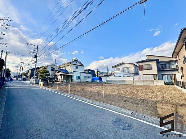 広々とした前面道路に面し、車の出し入れがしやすい現地外観。ゆとりある駐車スペースと開放感のある立地が魅力で、毎日の暮らしに快適さと安心をもたらすマイホームです。