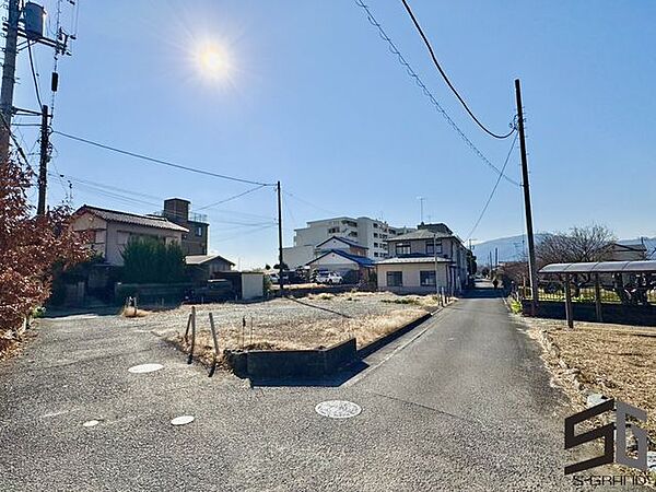 広々とした前面道路に面し、車の出し入れがしやすい現地外観。ゆとりある駐車スペースと開放感のある立地が魅力で、毎日の暮らしに快適さと安心をもたらすマイホームです。