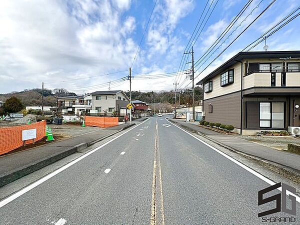 広々とした前面道路に面し、車の出し入れがしやすい現地外観。ゆとりある駐車スペースと開放感のある立地が魅力で、毎日の暮らしに快適さと安心をもたらすマイホームです。