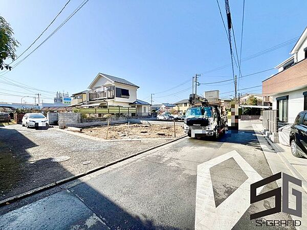 広々とした前面道路に面し、車の出し入れがしやすい現地外観。ゆとりある駐車スペースと開放感のある立地が魅力で、毎日の暮らしに快適さと安心をもたらすマイホームです。