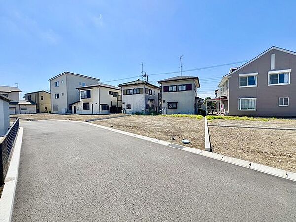 広々とした前面道路に面し、車の出し入れがしやすい現地外観。ゆとりある駐車スペースと開放感のある立地が魅力で、毎日の暮らしに快適さと安心をもたらすマイホームです。