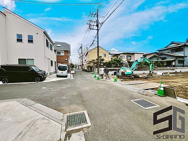 広々とした前面道路に面し、車の出し入れがしやすい現地外観。ゆとりある駐車スペースと開放感のある立地が魅力で、毎日の暮らしに快適さと安心をもたらすマイホームです。