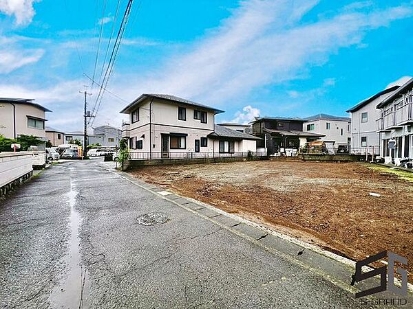 広々とした前面道路に面し、車の出し入れがしやすい現地外観。ゆとりある駐車スペースと開放感のある立地が魅力で、毎日の暮らしに快適さと安心をもたらすマイホームです。