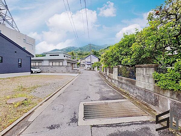 広々とした前面道路に面し、車の出し入れがしやすい現地外観。ゆとりある駐車スペースと開放感のある立地が魅力で、毎日の暮らしに快適さと安心をもたらすマイホームです。