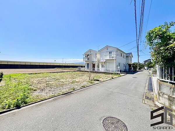 広々とした前面道路に面し、車の出し入れがしやすい現地外観。ゆとりある駐車スペースと開放感のある立地が魅力で、毎日の暮らしに快適さと安心をもたらすマイホームです。