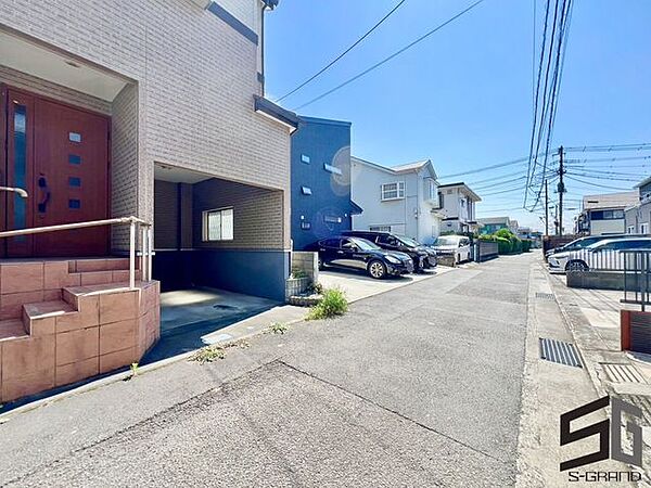 広々とした前面道路に面し、車の出し入れがしやすい現地外観。ゆとりある駐車スペースと開放感のある立地が魅力で、毎日の暮らしに快適さと安心をもたらすマイホームです。