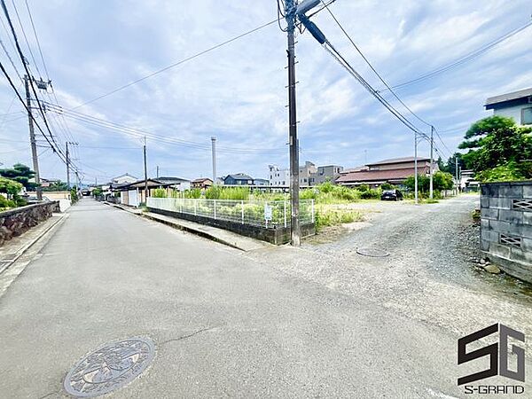 広々とした前面道路に面し、車の出し入れがしやすい現地外観。ゆとりある駐車スペースと開放感のある立地が魅力で、毎日の暮らしに快適さと安心をもたらすマイホームです。