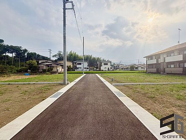 広々とした前面道路に面し、車の出し入れがしやすい現地外観。ゆとりある駐車スペースと開放感のある立地が魅力で、毎日の暮らしに快適さと安心をもたらすマイホームです。