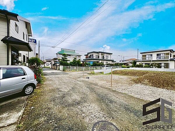 広々とした前面道路に面し、車の出し入れがしやすい現地外観。ゆとりある駐車スペースと開放感のある立地が魅力で、毎日の暮らしに快適さと安心をもたらすマイホームです。